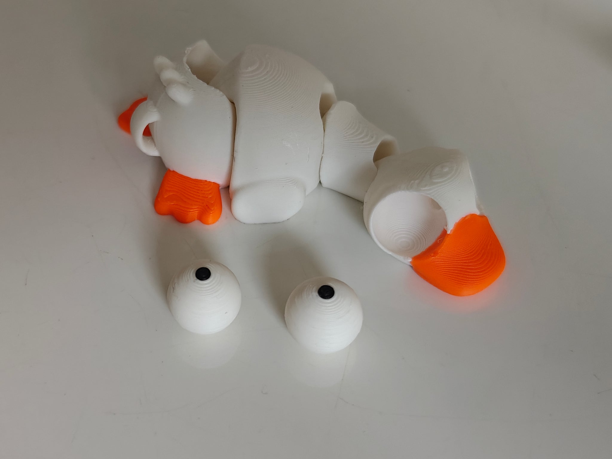 Close-up of mini flexi goose figure with large movable googly eyes on white background