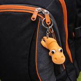 Small orange dino keychain hanging from sturdy metal chain on keyring
