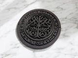 Close-up of Celtic runestone coaster showing detailed rune carvings and ornamental patterns