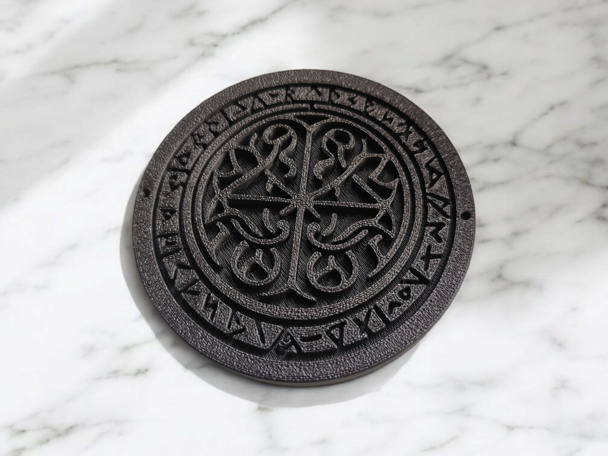 Close-up of Celtic runestone coaster showing detailed rune carvings and ornamental patterns