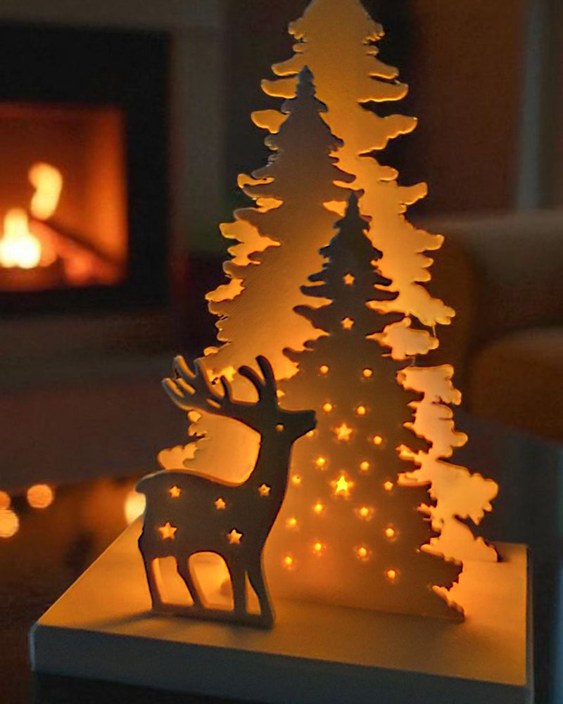Christmas decoration with deer and tree design, tealight holder slot visible from the back
