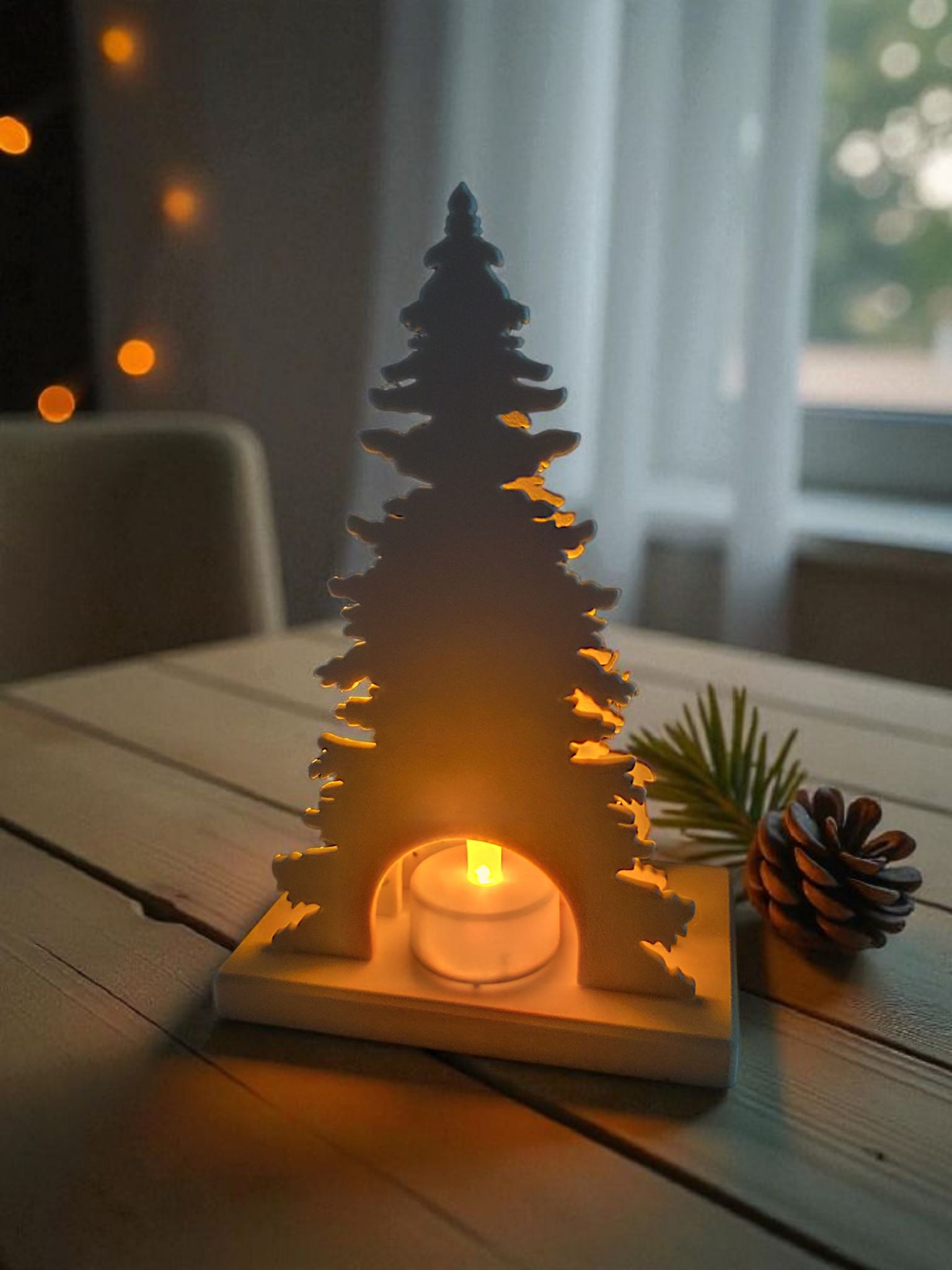 Christmas decoration with deer and tree design, tealight holder slot visible from the back