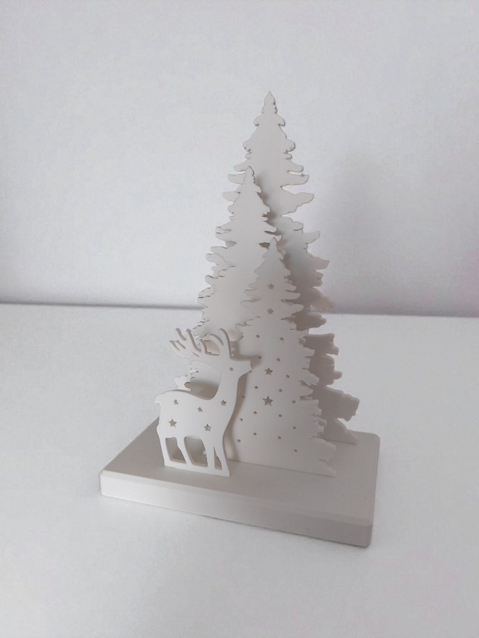 Christmas decoration with deer and tree design, tealight holder slot visible from the back