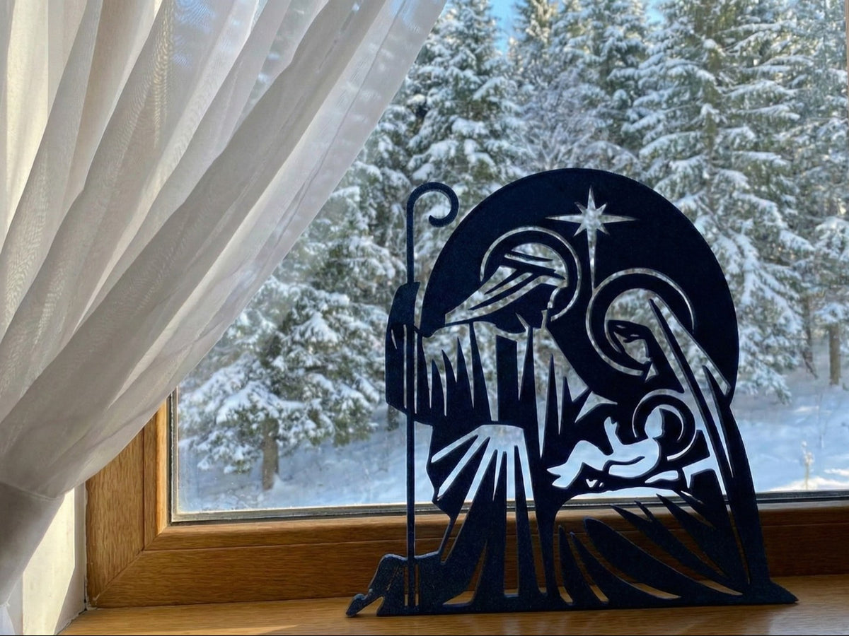 Julekrybbe i silhuet med Josef, Maria, Jesusbarnet og stjerne