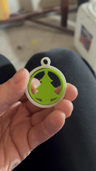 Grønt juletræ i hvid ring som juletræspynt