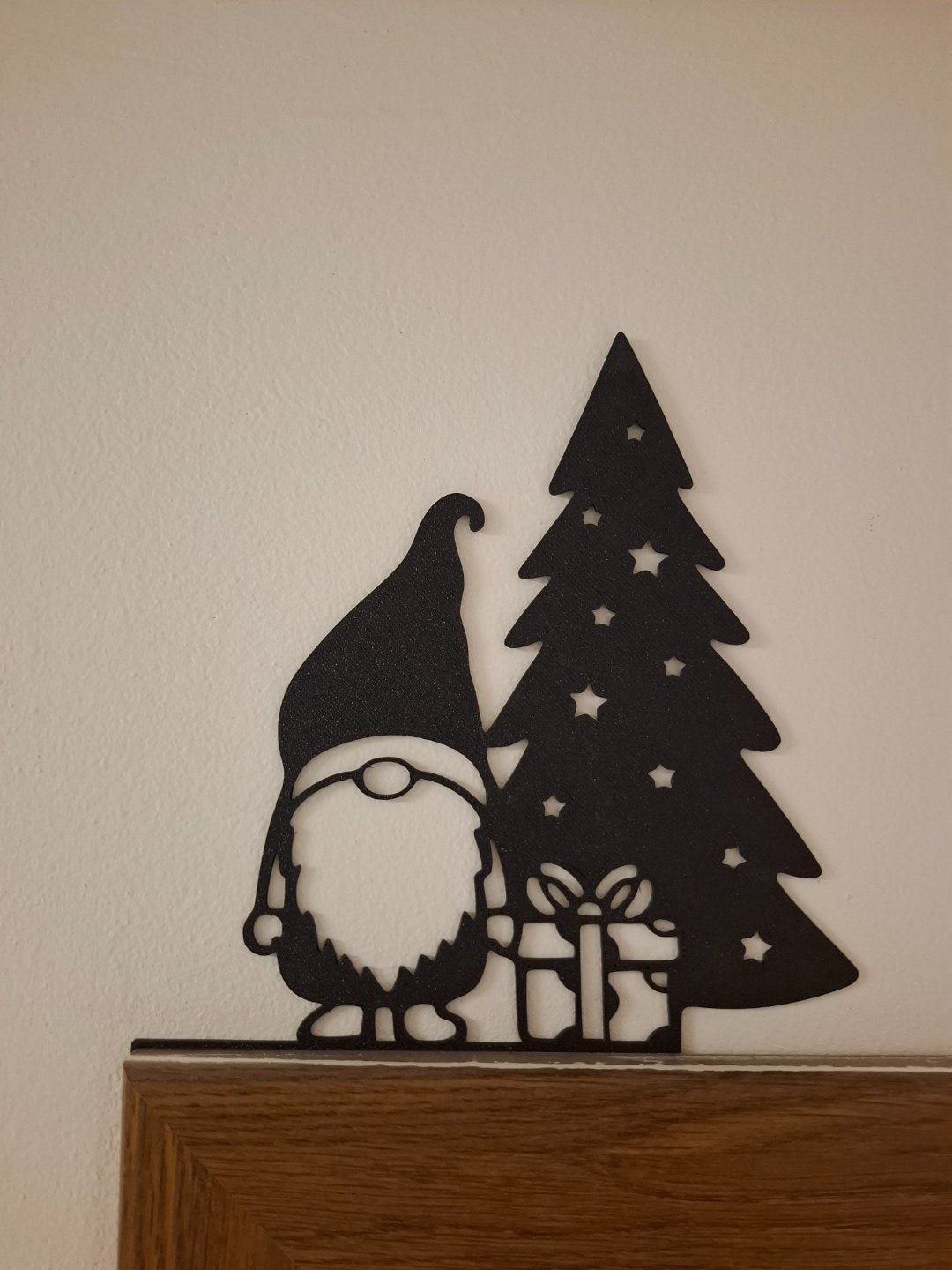 Nissefigur med gave ved juletræet