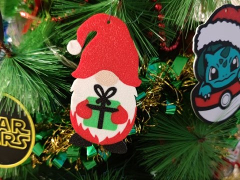 Festlig nisse med rød hue og gave i hænderne