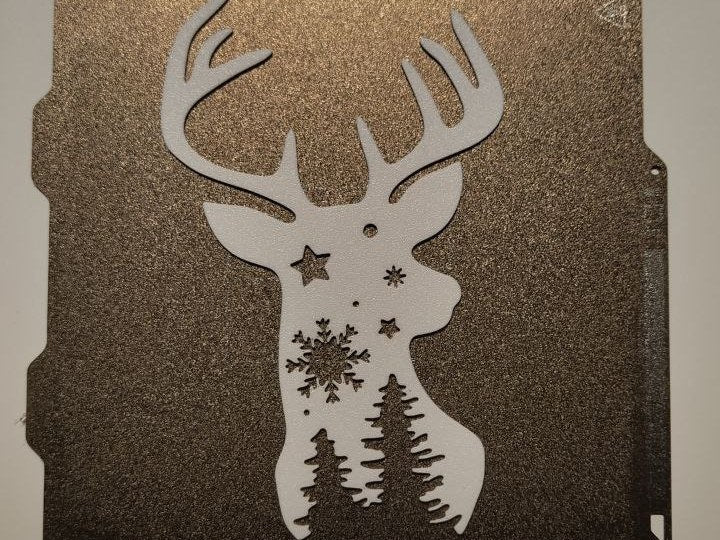 Rensdyrsilhuet med stjerner og juletræer