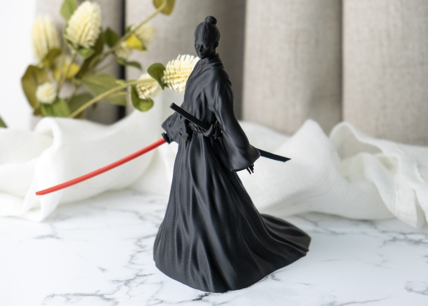 Close-up detail of female samurai figurine showing robe folds and sword line