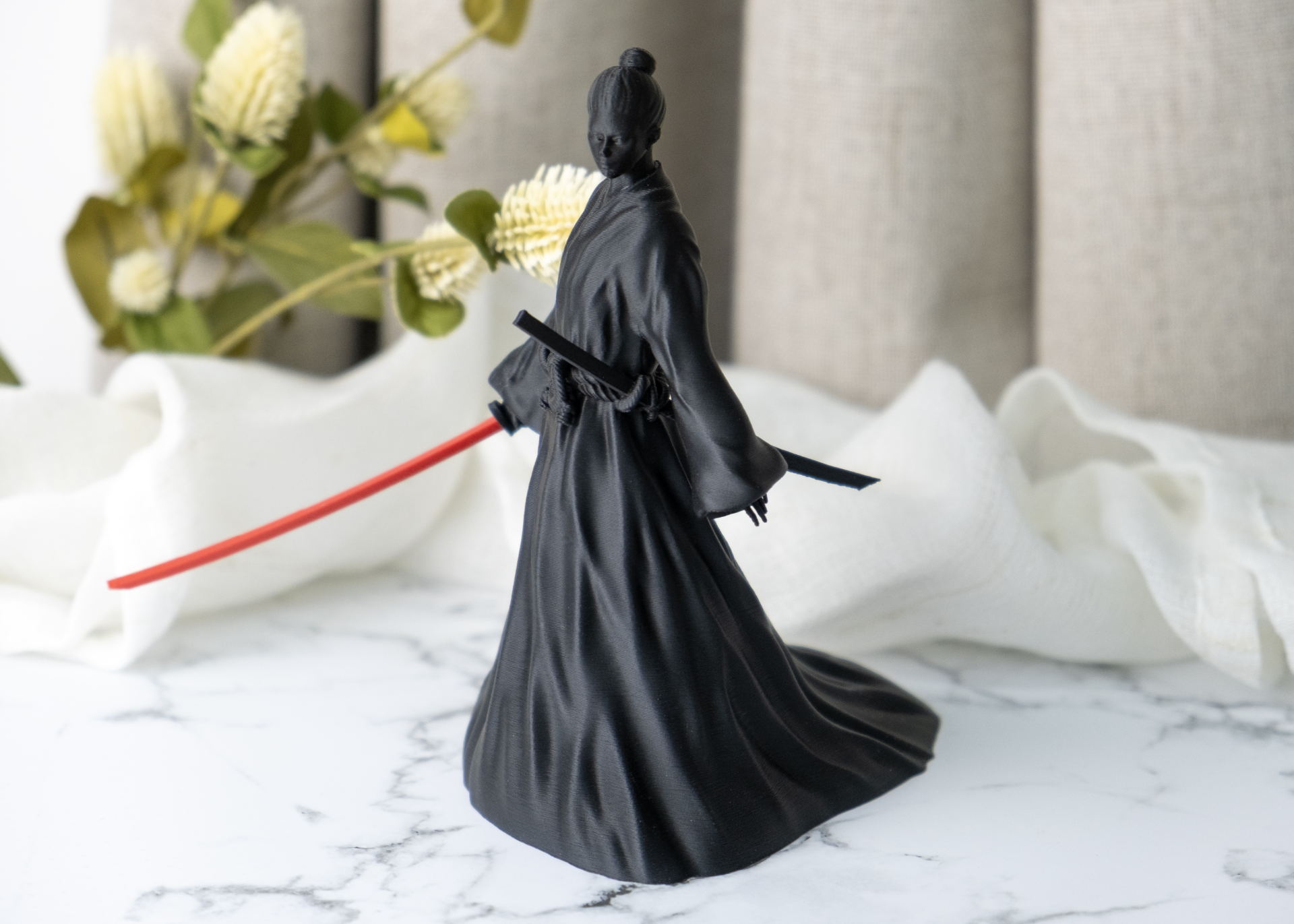 Close-up detail of female samurai figurine showing robe folds and sword line