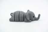 Close-up of a knitted elephant keychain with textured crochet-like surface and articulated body segments
