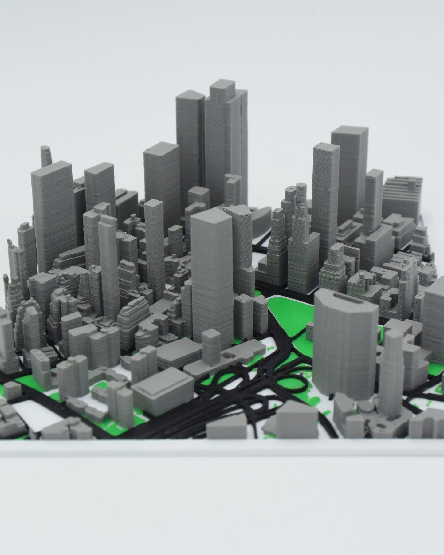 Personalized 3D map of a coastal town displayed on a wooden shelf beside books and a small plant