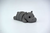 Close-up of a knitted hippo figurine with textured crochet-look surface, photographed on a white background