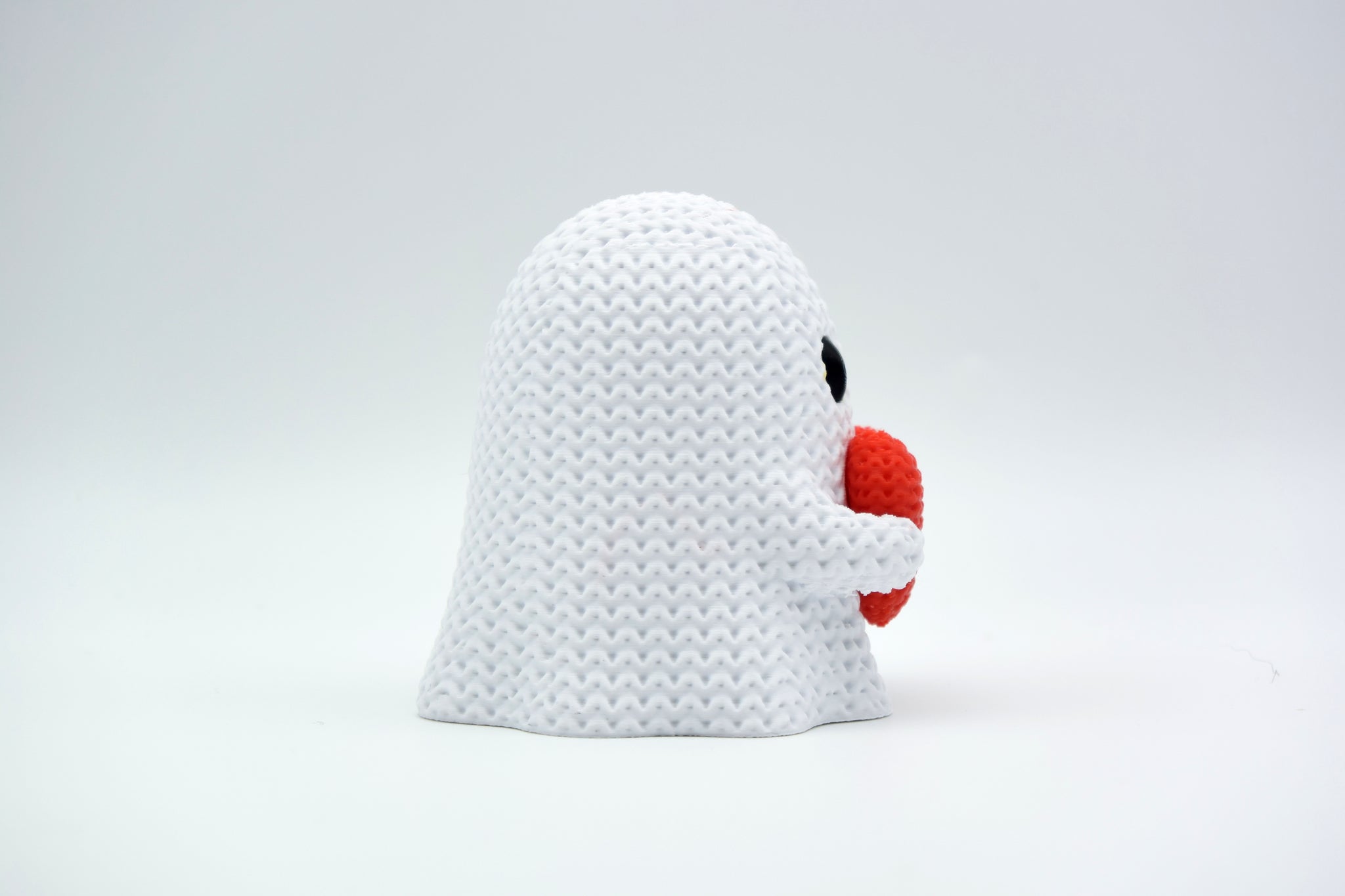 Close-up of a knitted ghost decoration with a heart detail, soft crochet texture in white and red, 49 DKK