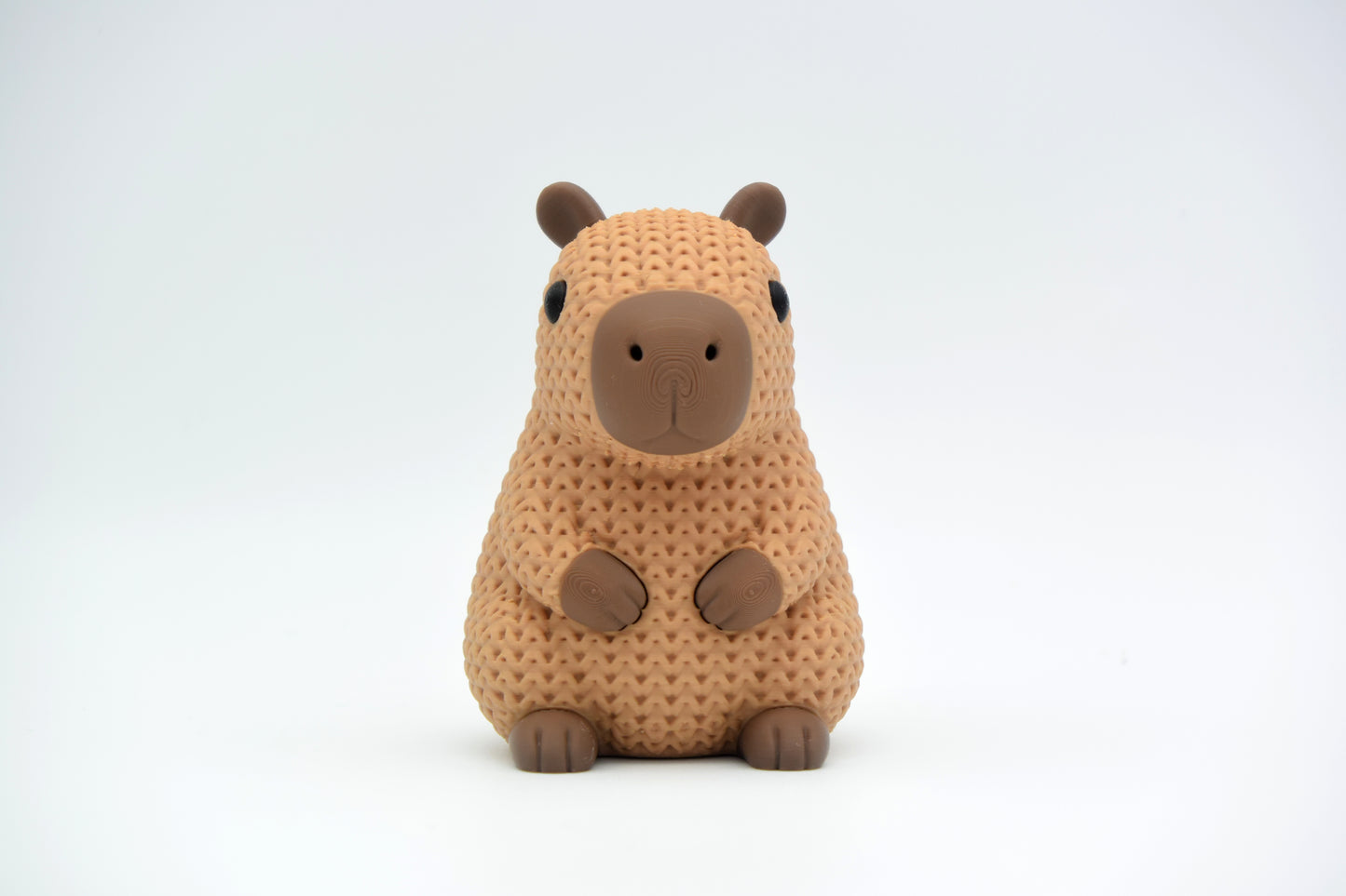 Texture detail of knitted capybara showing the open crochet-like weave pattern across the body of the figure