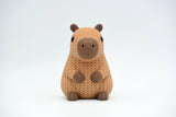 Texture detail of knitted capybara showing the open crochet-like weave pattern across the body of the figure